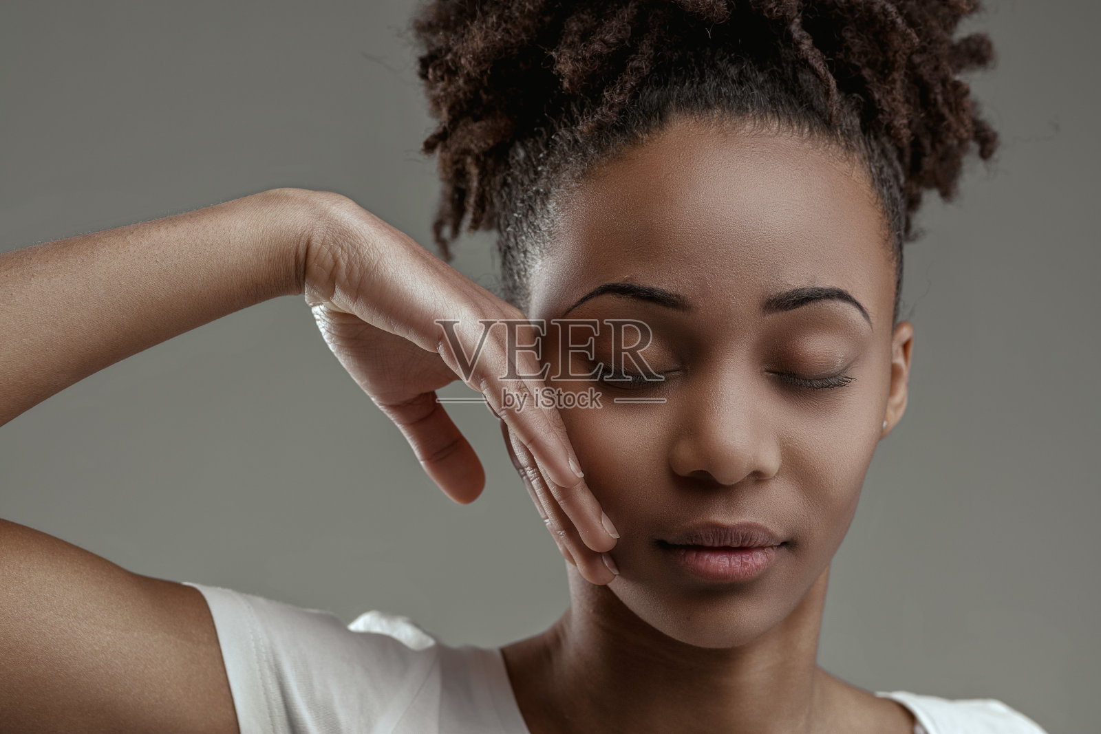 年轻的黑人女子抚摸着脸，轻轻地闭上眼睛照片摄影图片