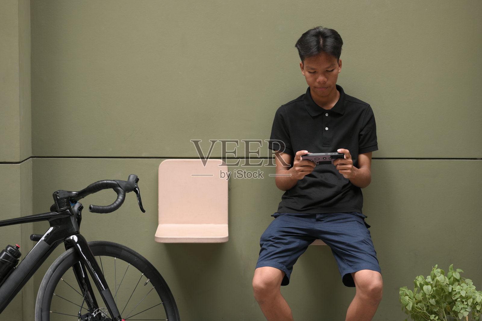 十几岁的男孩带着笔记本电脑度假，骑着自行车照片摄影图片