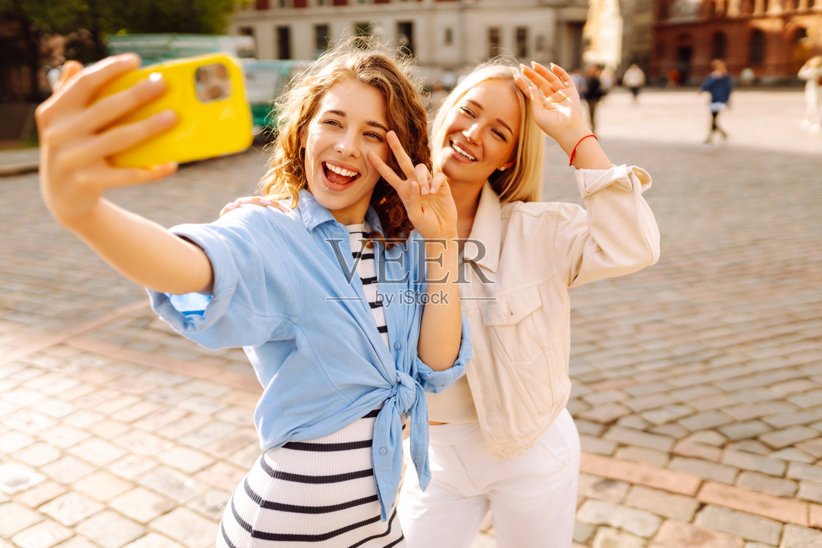 快乐的女人走在街上自拍。照片摄影图片