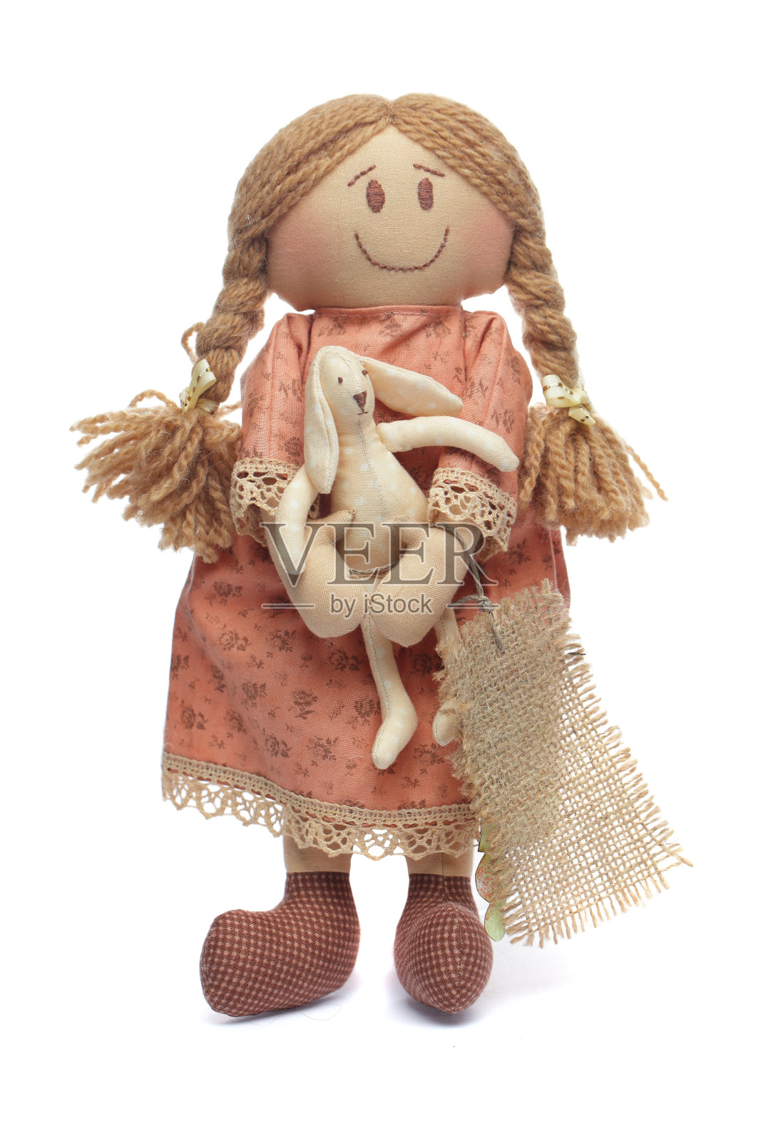 可爱的手工娃娃与复活节兔子在她的手在白色的背景照片摄影图片