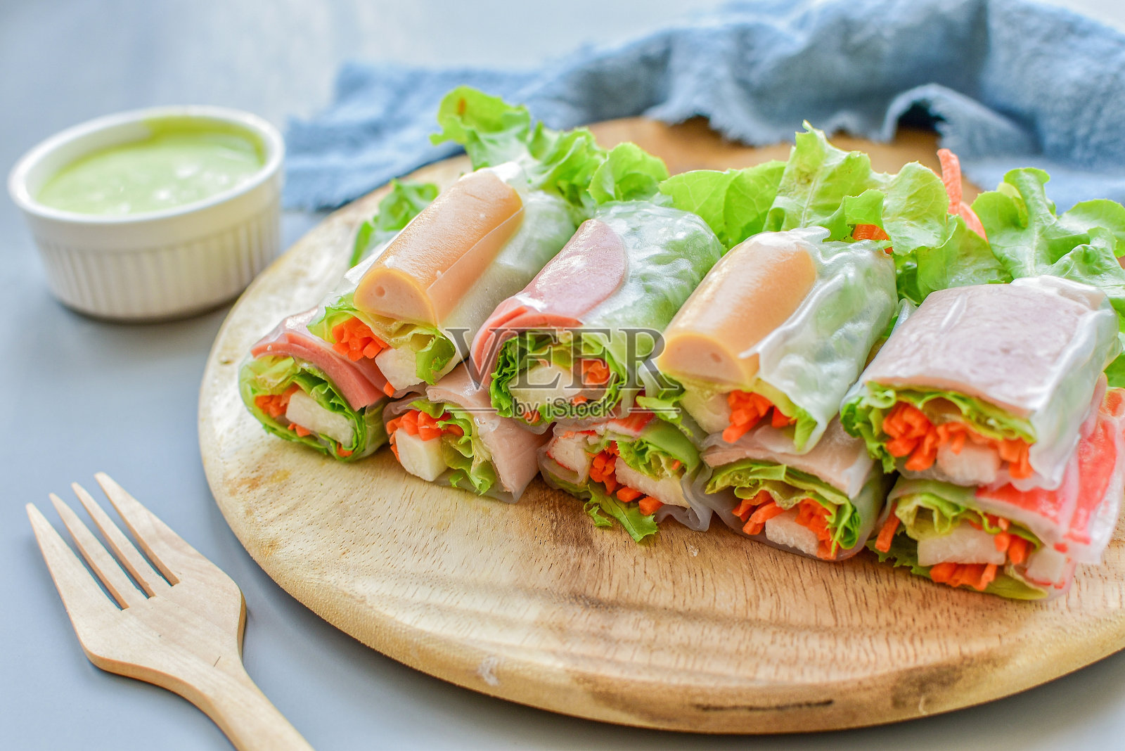 木质盘子里的沙拉卷照片摄影图片