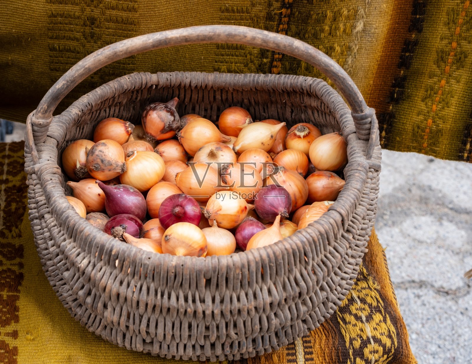 桌子上放着一篮洋葱，一种天然的食品原料照片摄影图片