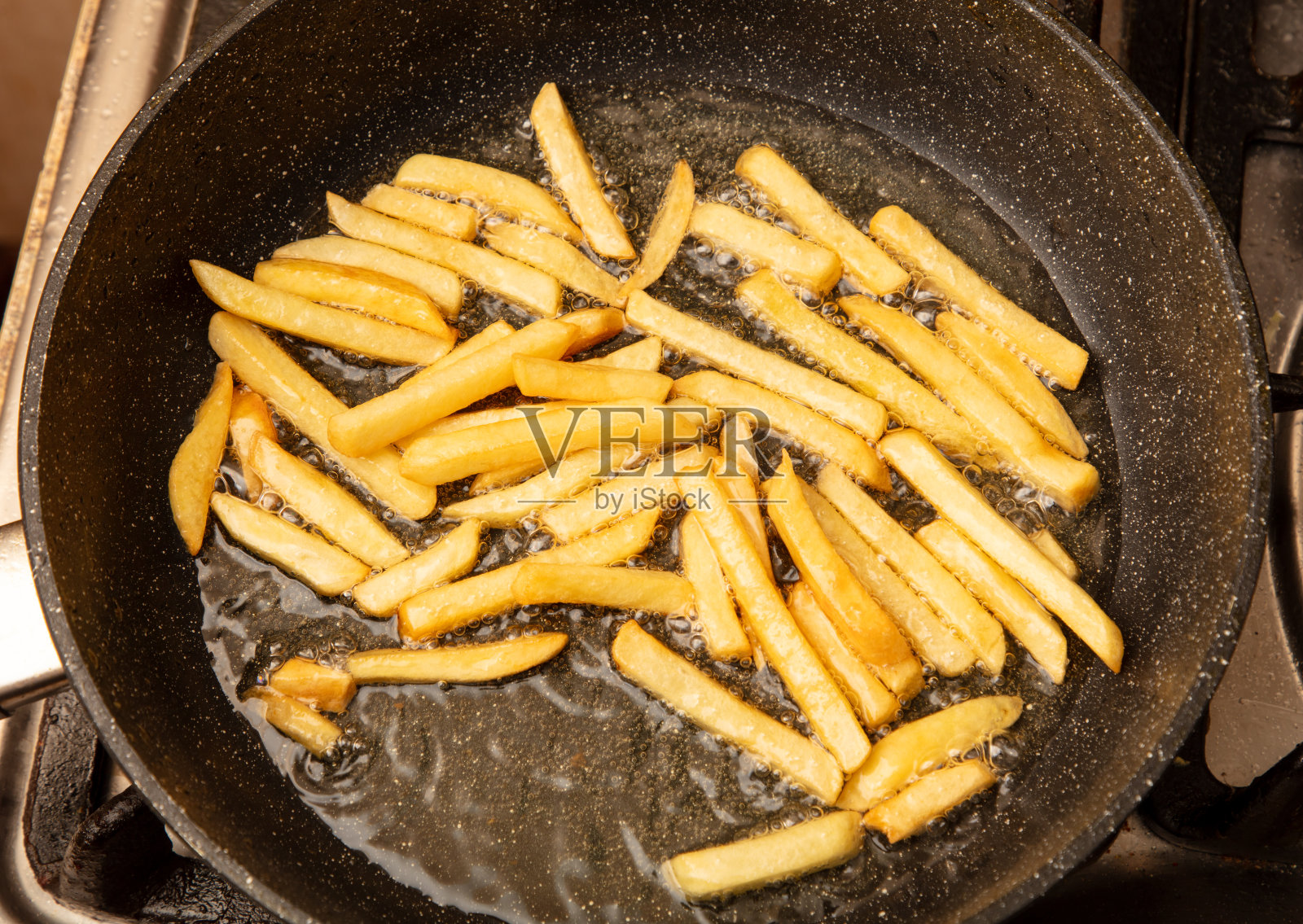 炸薯条是在煎锅里用油煎的照片摄影图片