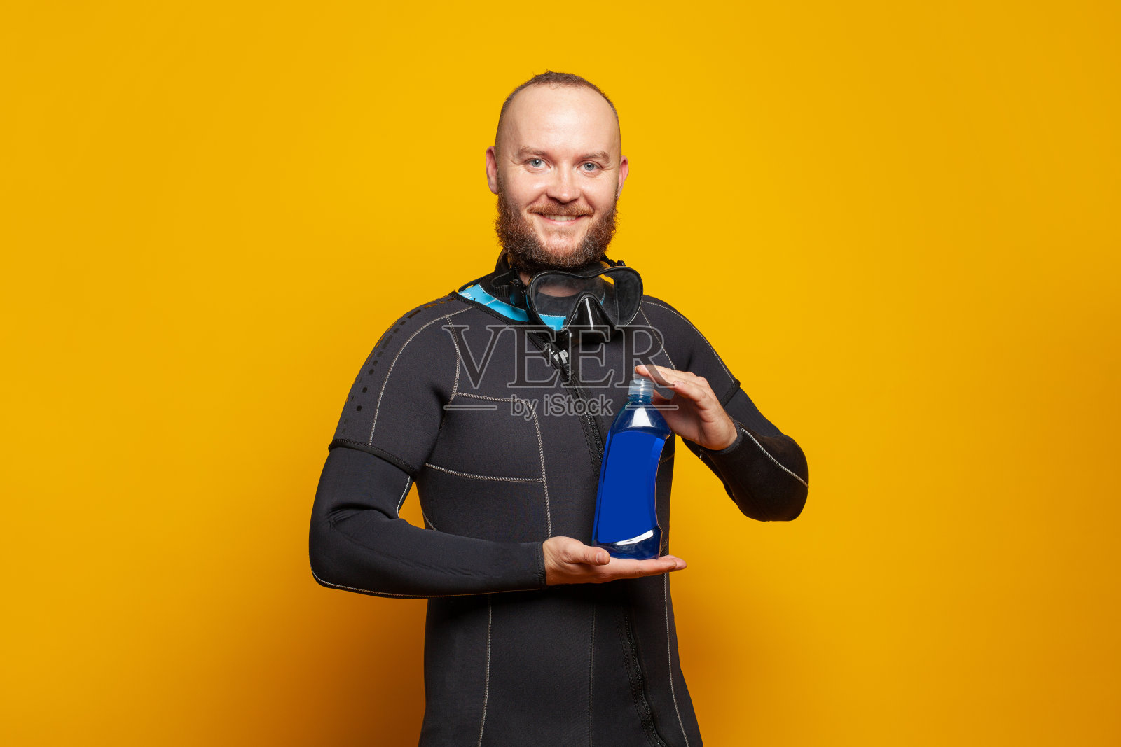 潜水员拿着彩色橙色背景的塑料瓶照片摄影图片