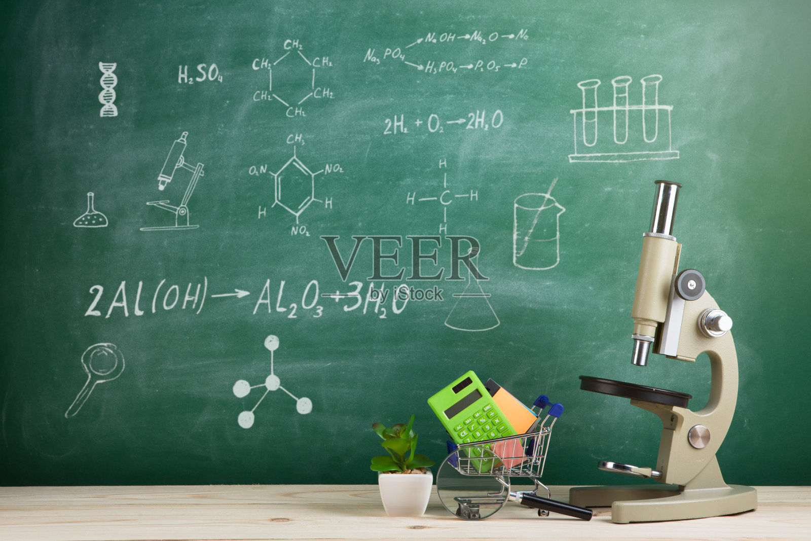 教育理念——礼堂里的桌子上放着显微镜，背景是黑板照片摄影图片