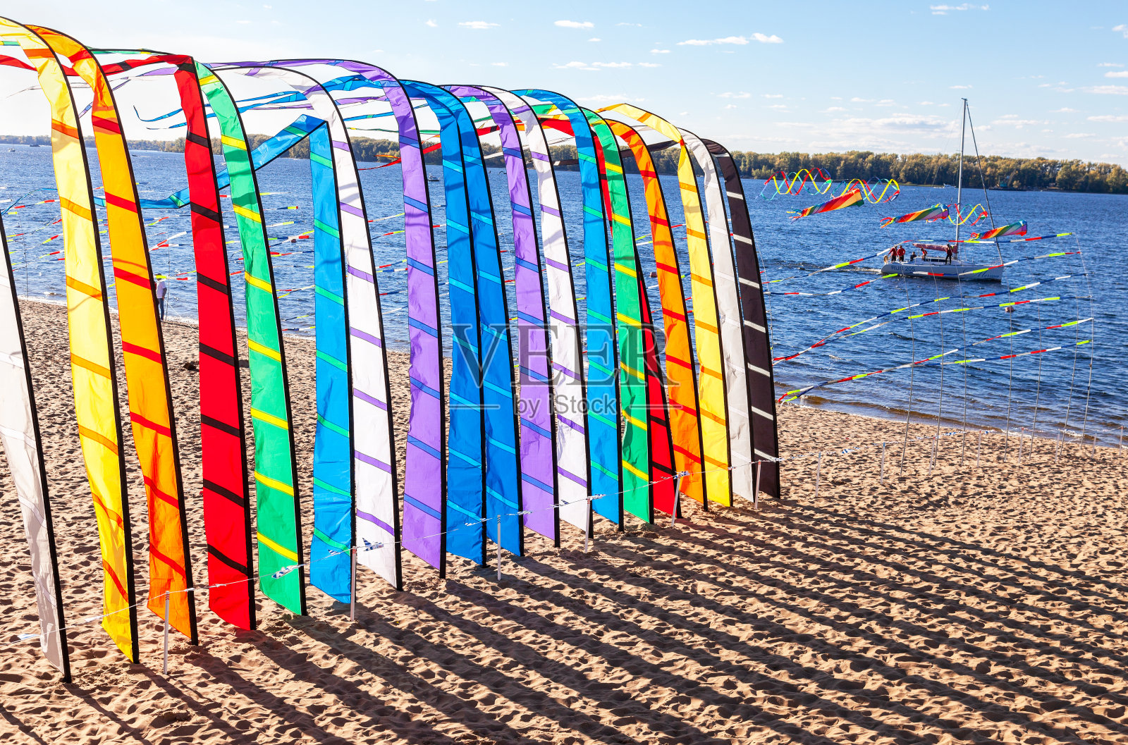 在一个阳光明媚的假期里，装饰彩旗在沙滩上飘扬照片摄影图片