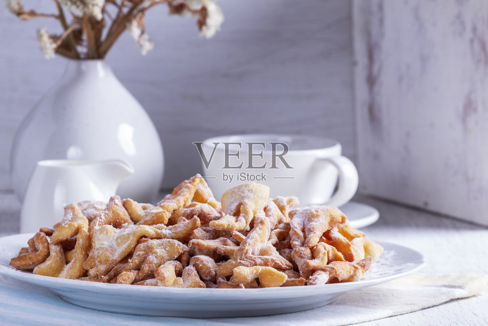 传统的Maslenitsa甜点天使翅膀与咖啡在浅色背景。照片摄影图片