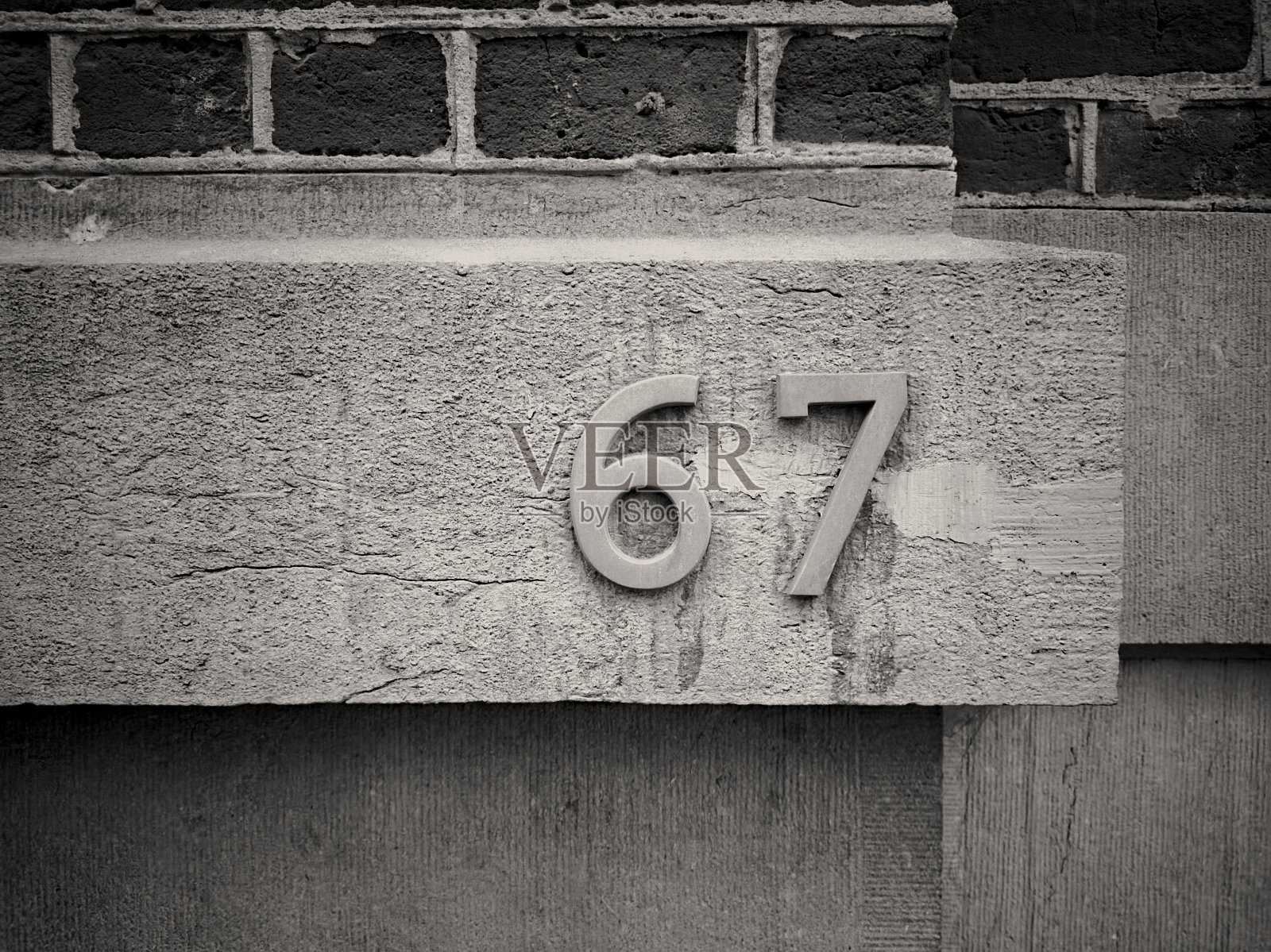 金属漆的数字六十七或六十七用拉丁字母应用在建筑上。照片摄影图片