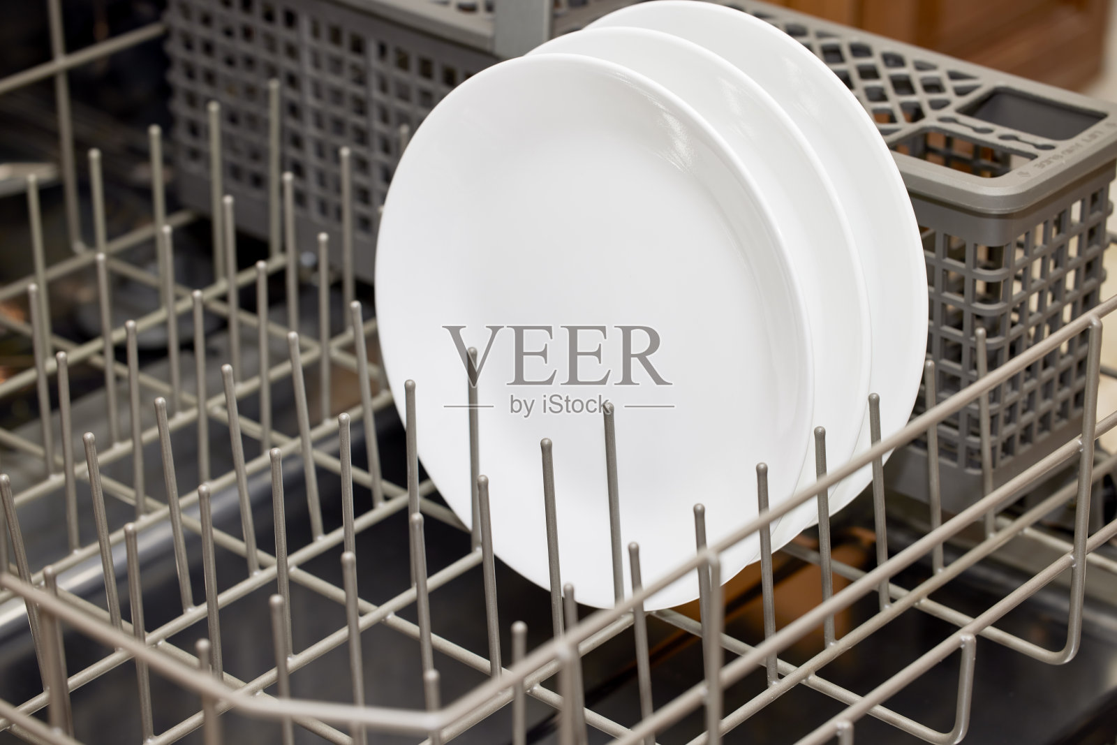 洗碗机底部架子上白色陶瓷盘子的近照照片摄影图片