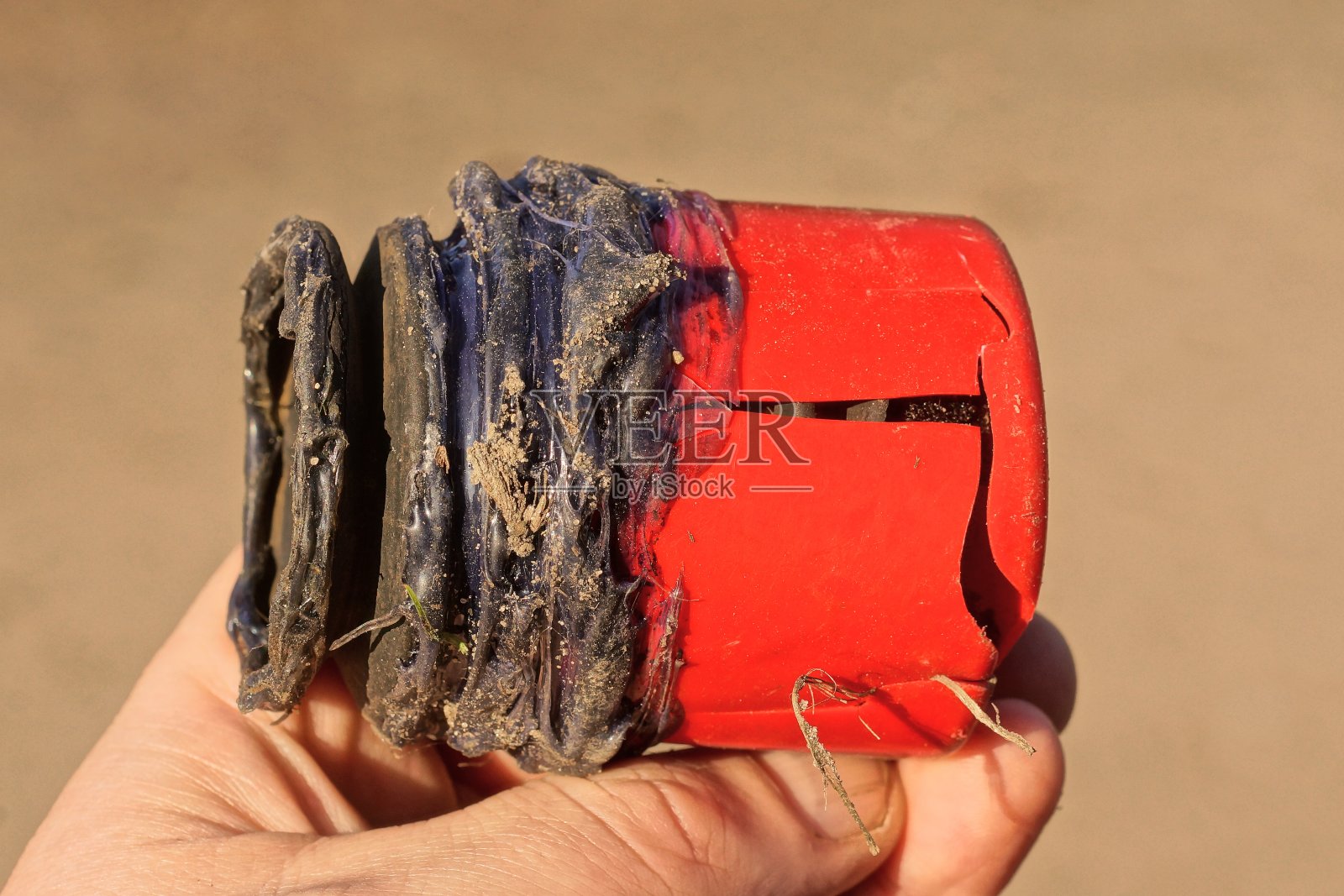 手里拿着一根旧的黑色塑料水管照片摄影图片