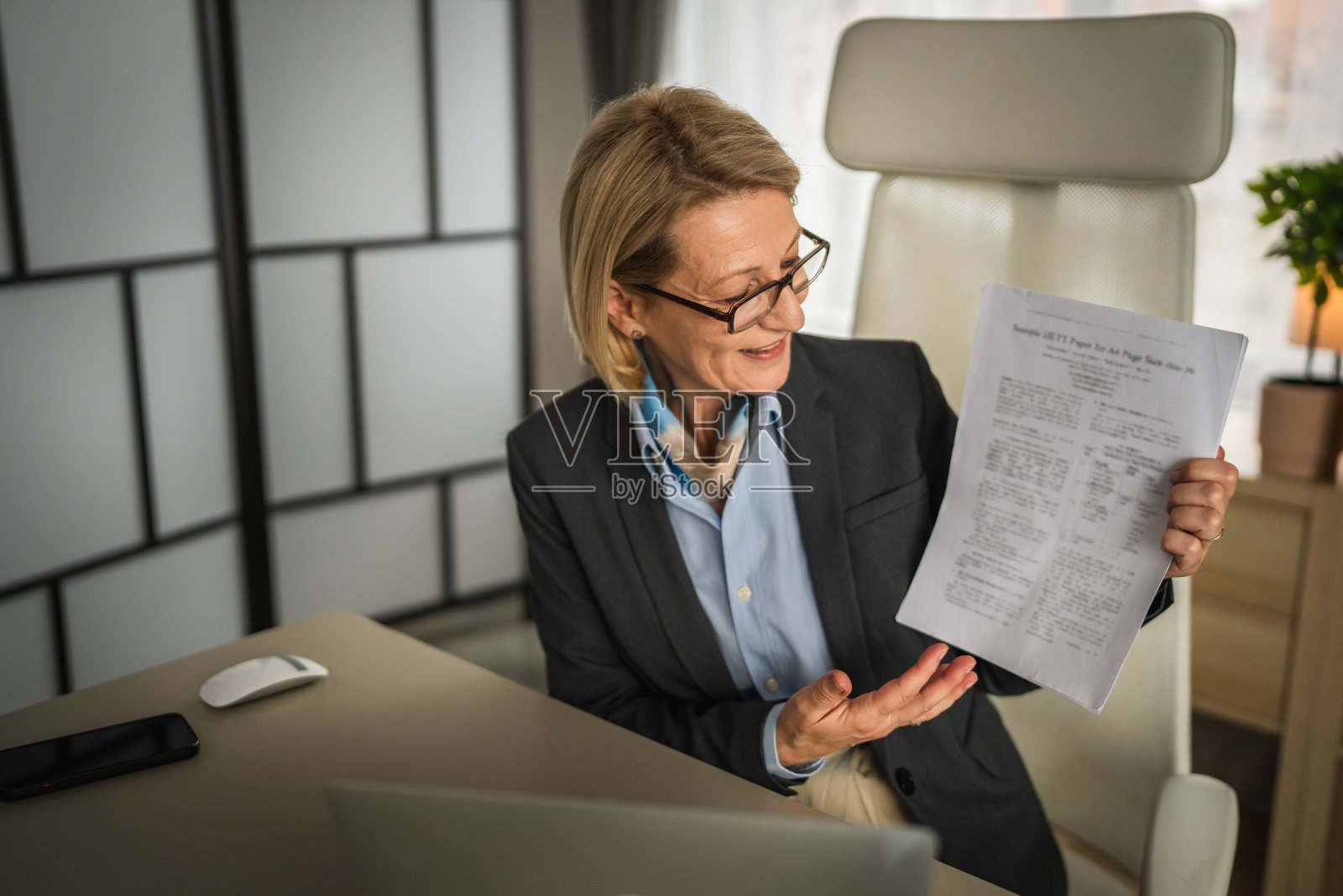 成熟的女商人在办公室用笔记本电脑进行视频通话照片摄影图片