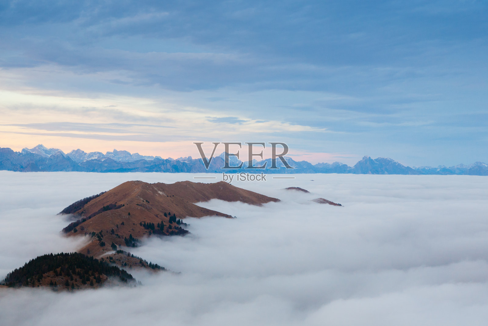 山峰从云层中显露出来照片摄影图片