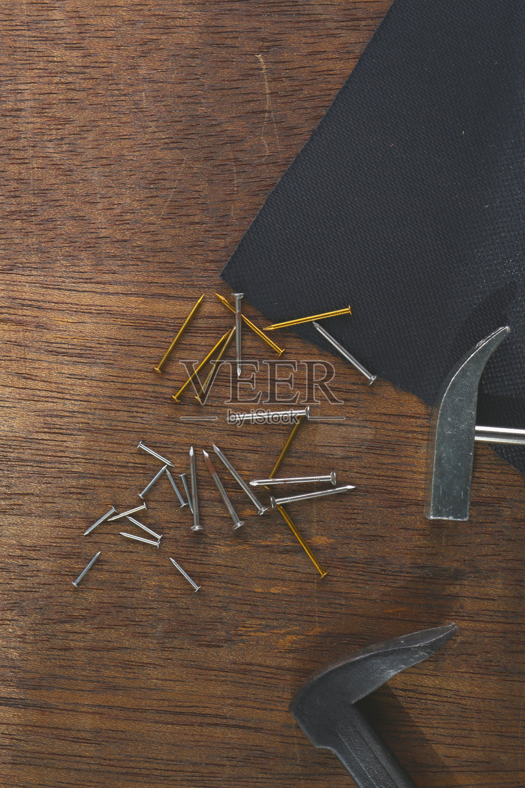 锤子和钉子放在棕色的木桌上照片摄影图片
