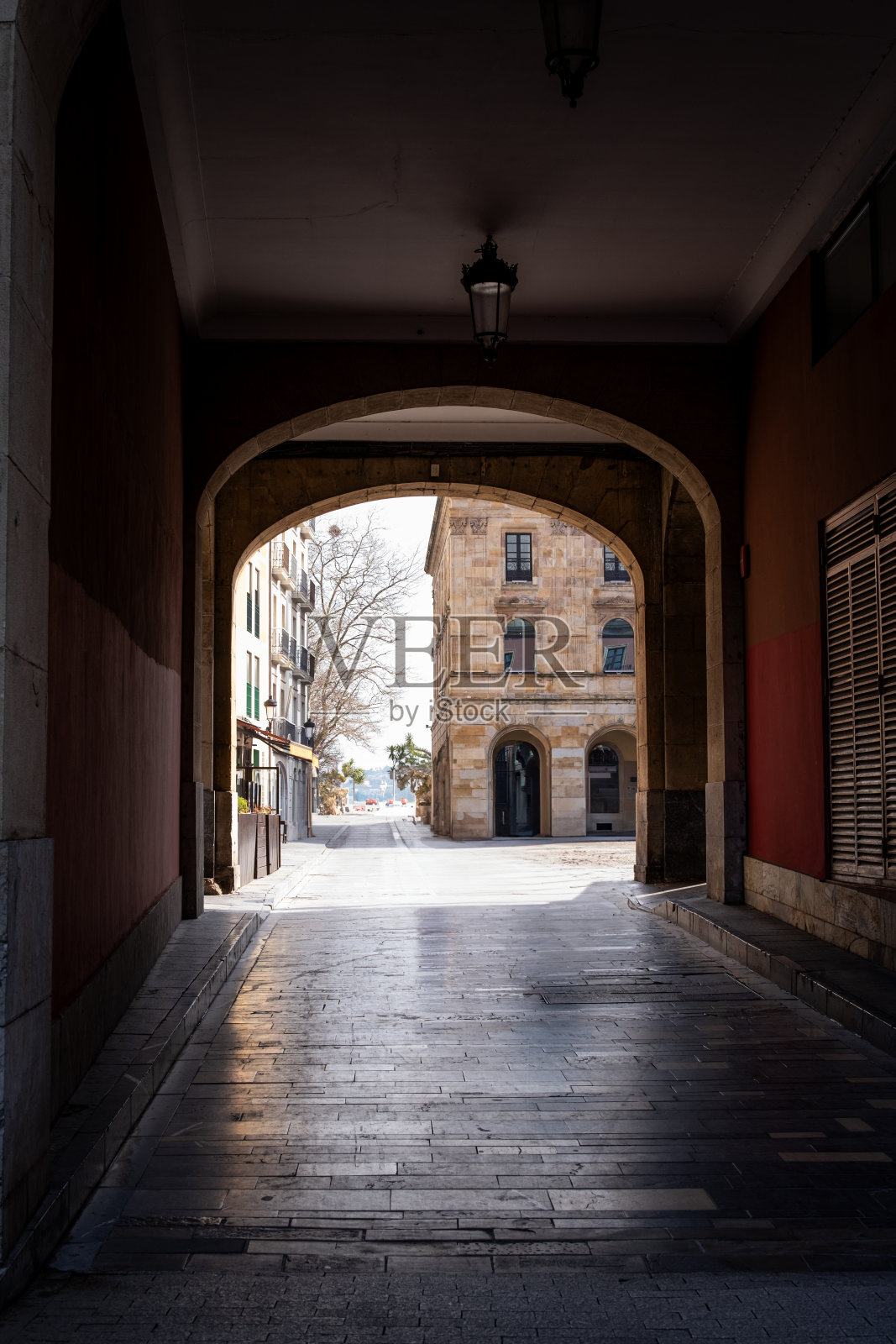 在灰暗多云的天空下探索Gijón的城市背景，揭示其隐藏的通道。照片摄影图片