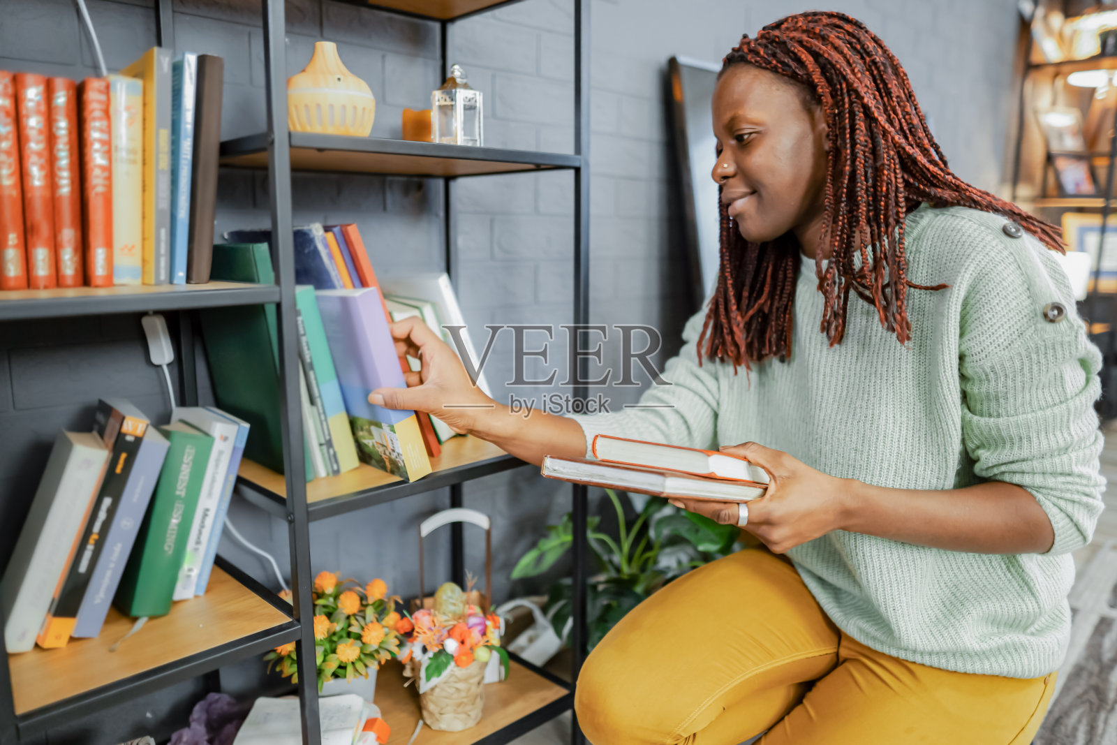 黑人妇女在家里整理她的书架照片摄影图片