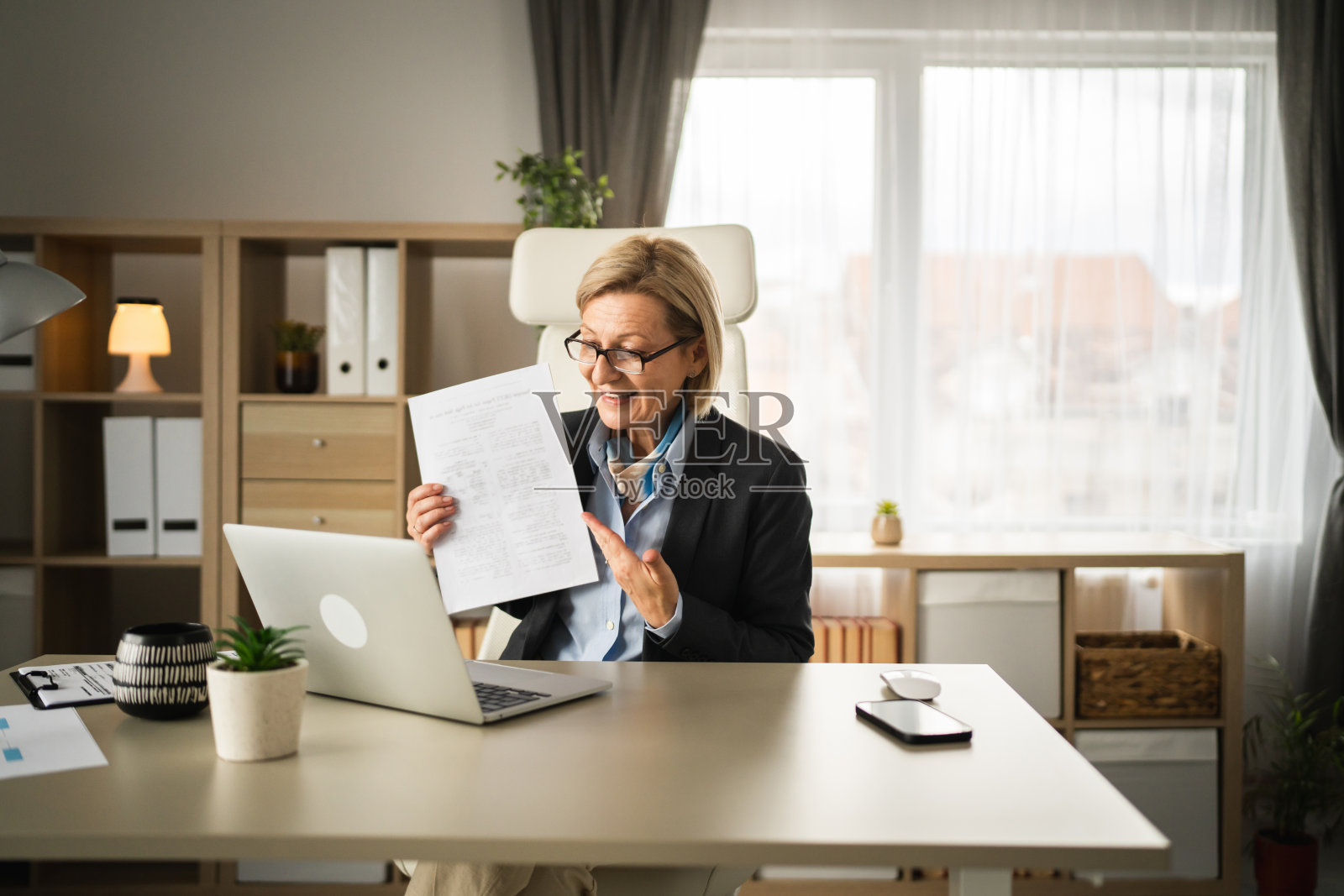 成熟的女商人在办公室用笔记本电脑进行视频通话照片摄影图片