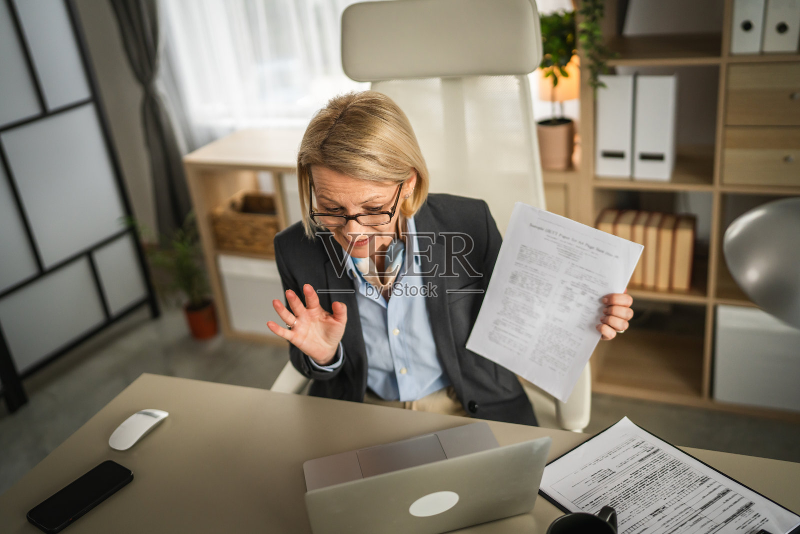 成熟的女商人在办公室用笔记本电脑进行视频通话照片摄影图片