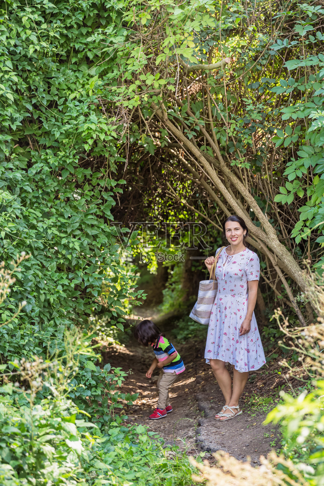 妈妈和帅气的小男孩在森林里散步照片摄影图片