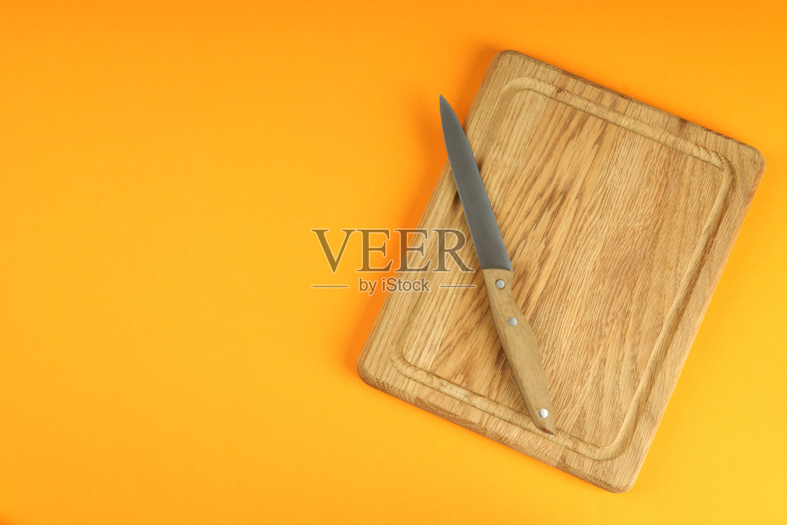切菜板上的刀在橙色的背景照片摄影图片
