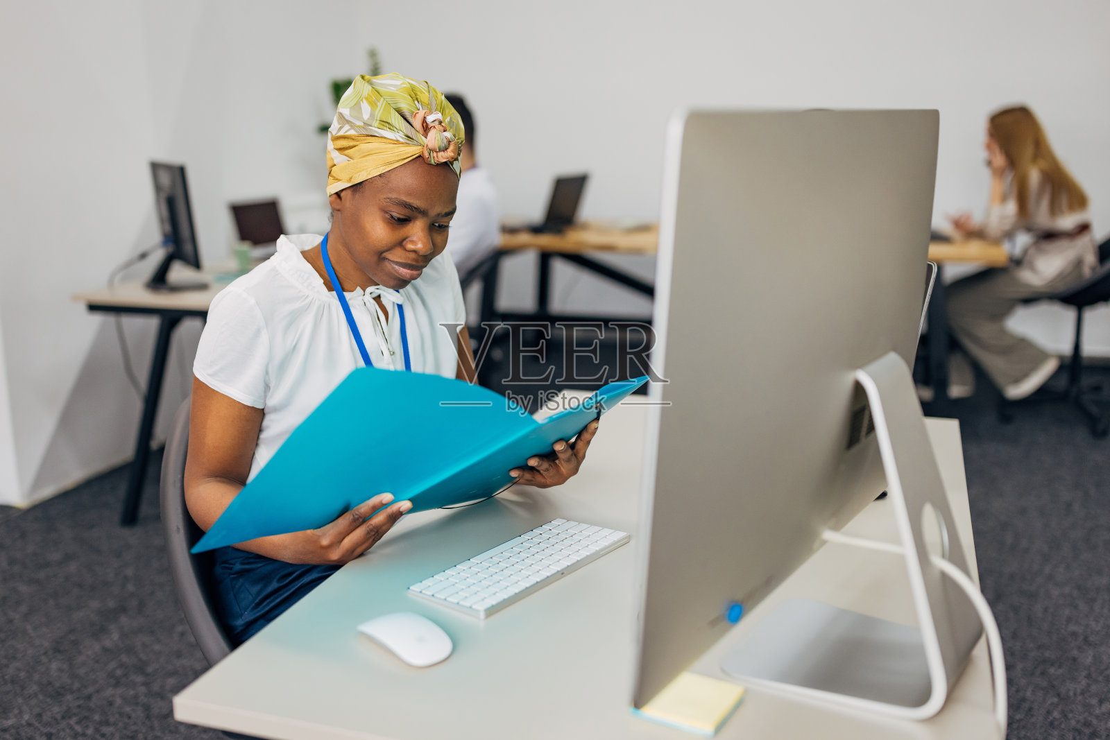 在办公室工作的黑人员工，坐在办公桌前使用笔记本电脑和电脑照片摄影图片