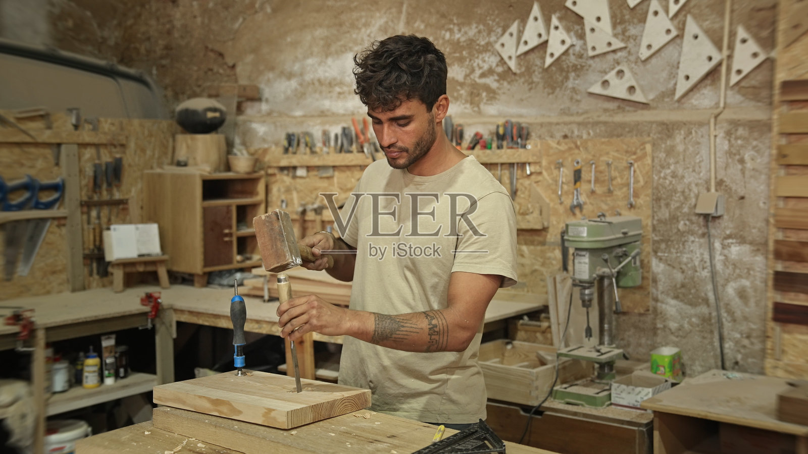 木匠用凿子雕刻木头。在车间做木工工作。乔伊纳木制品。照片摄影图片