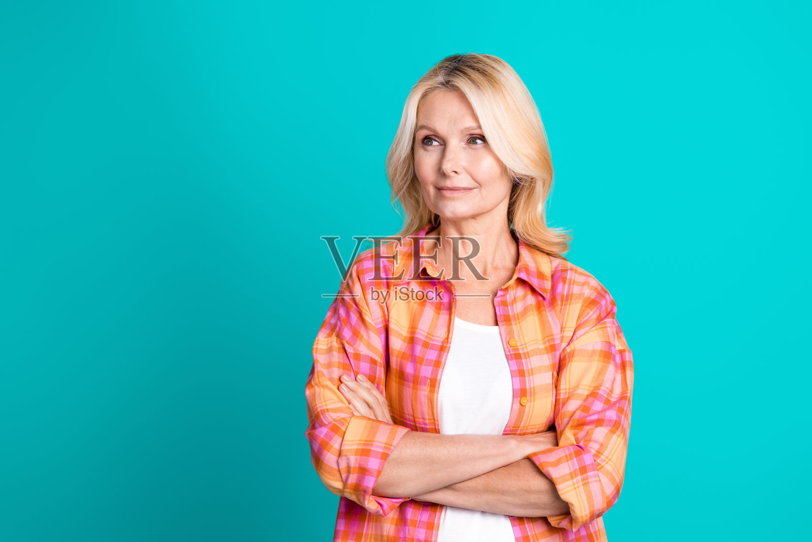 自信的女性养老金领取者的肖像，穿着格子时尚的衣服，双臂交叉，空白空间孤立在青色背景上照片摄影图片