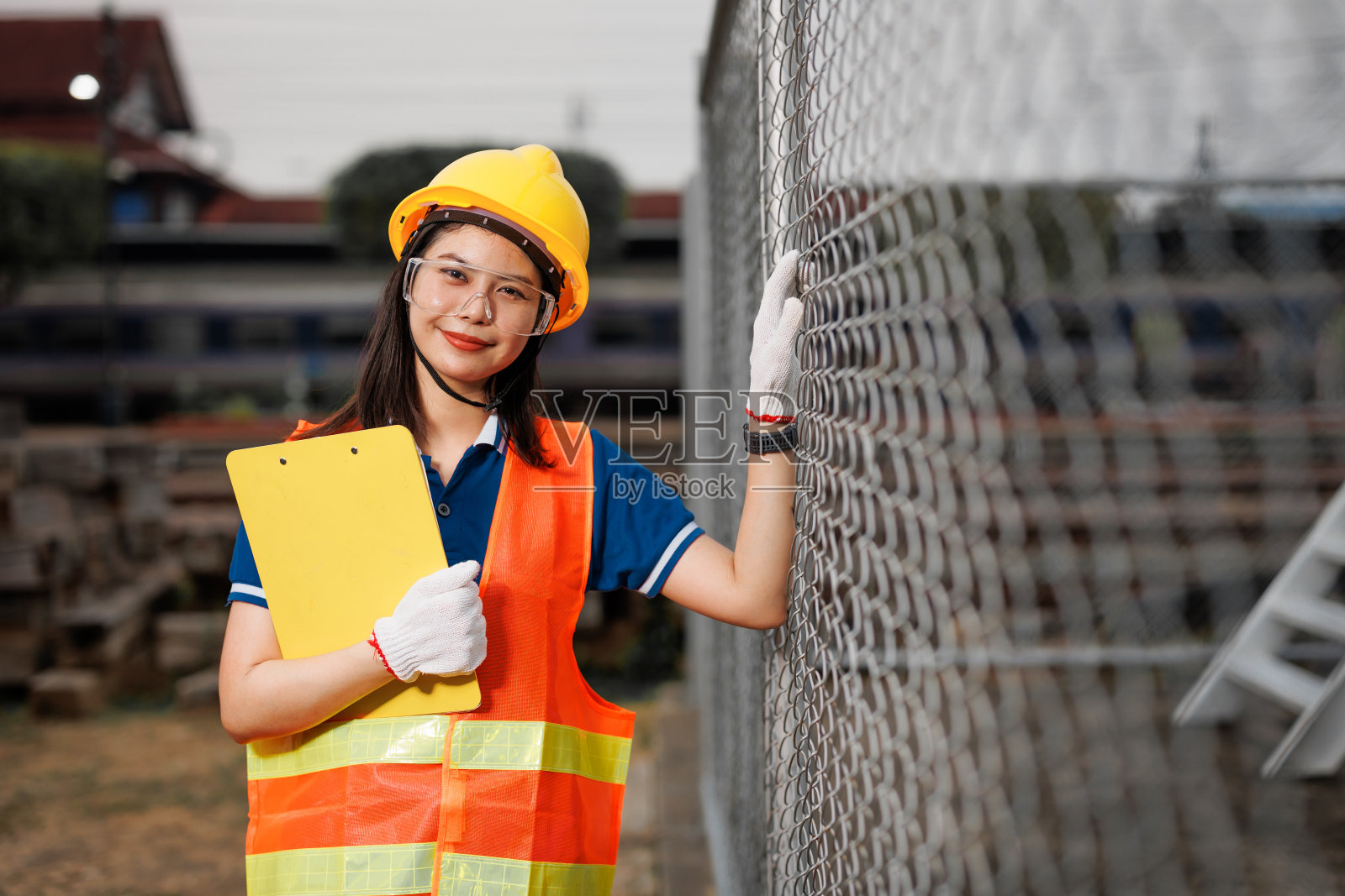 亚洲青年工程师工人站在户外快乐地微笑，用安全帽提醒安全。照片摄影图片