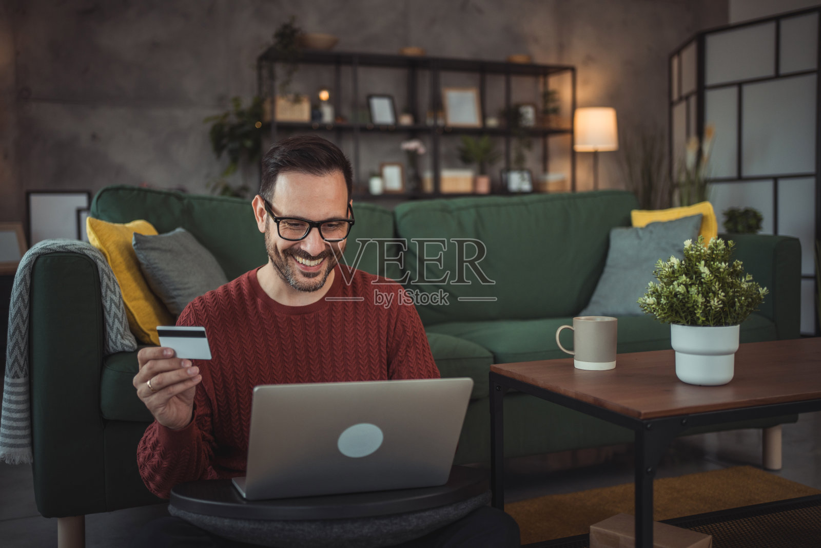 家里有笔记本电脑和信用卡的帅哥照片摄影图片