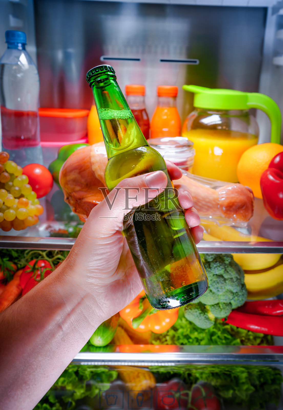 男子从冰箱里拿啤酒照片摄影图片