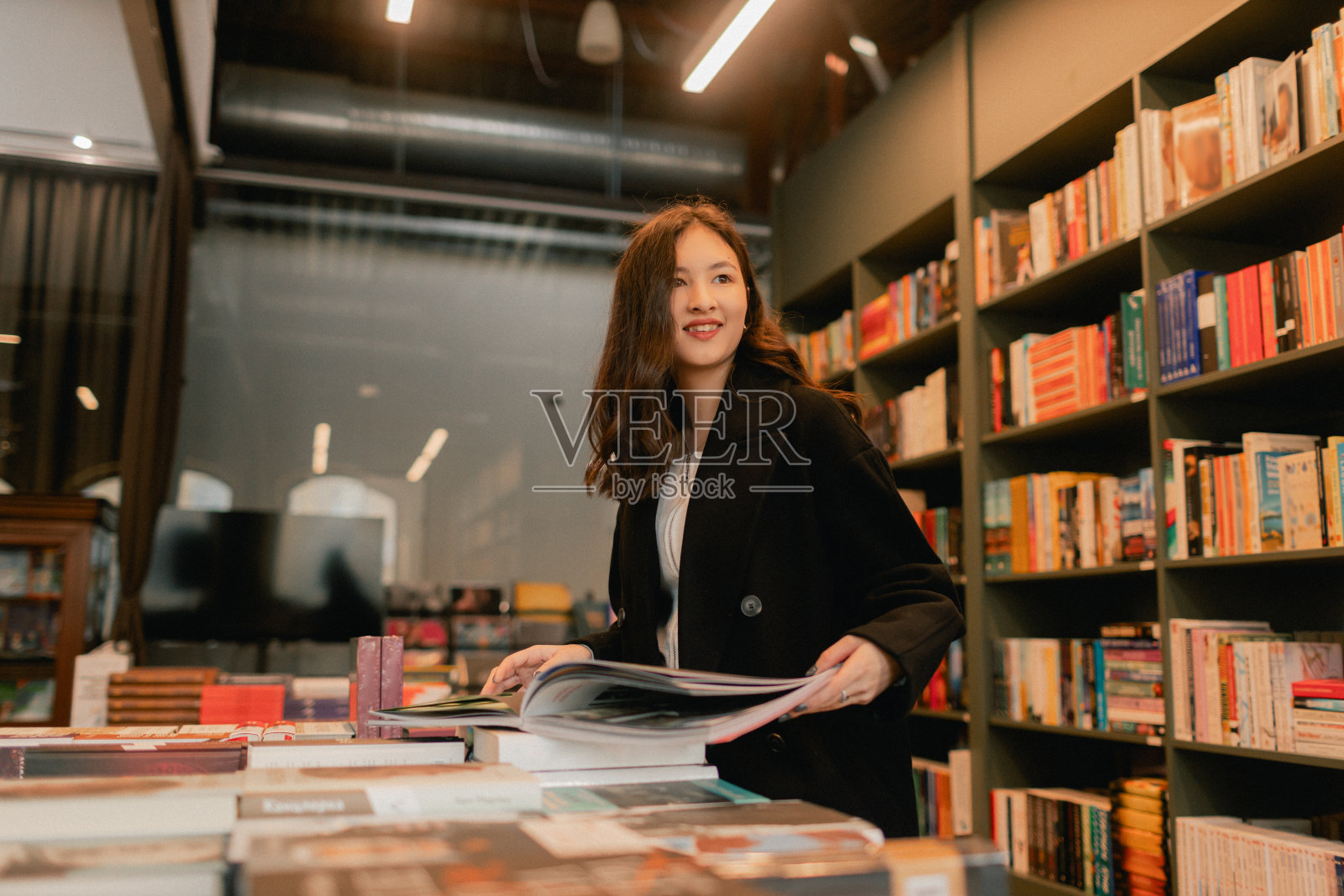 漂亮的Z代韩国女学生在书店里挑选书。教育培训理念。系列的一部分照片摄影图片