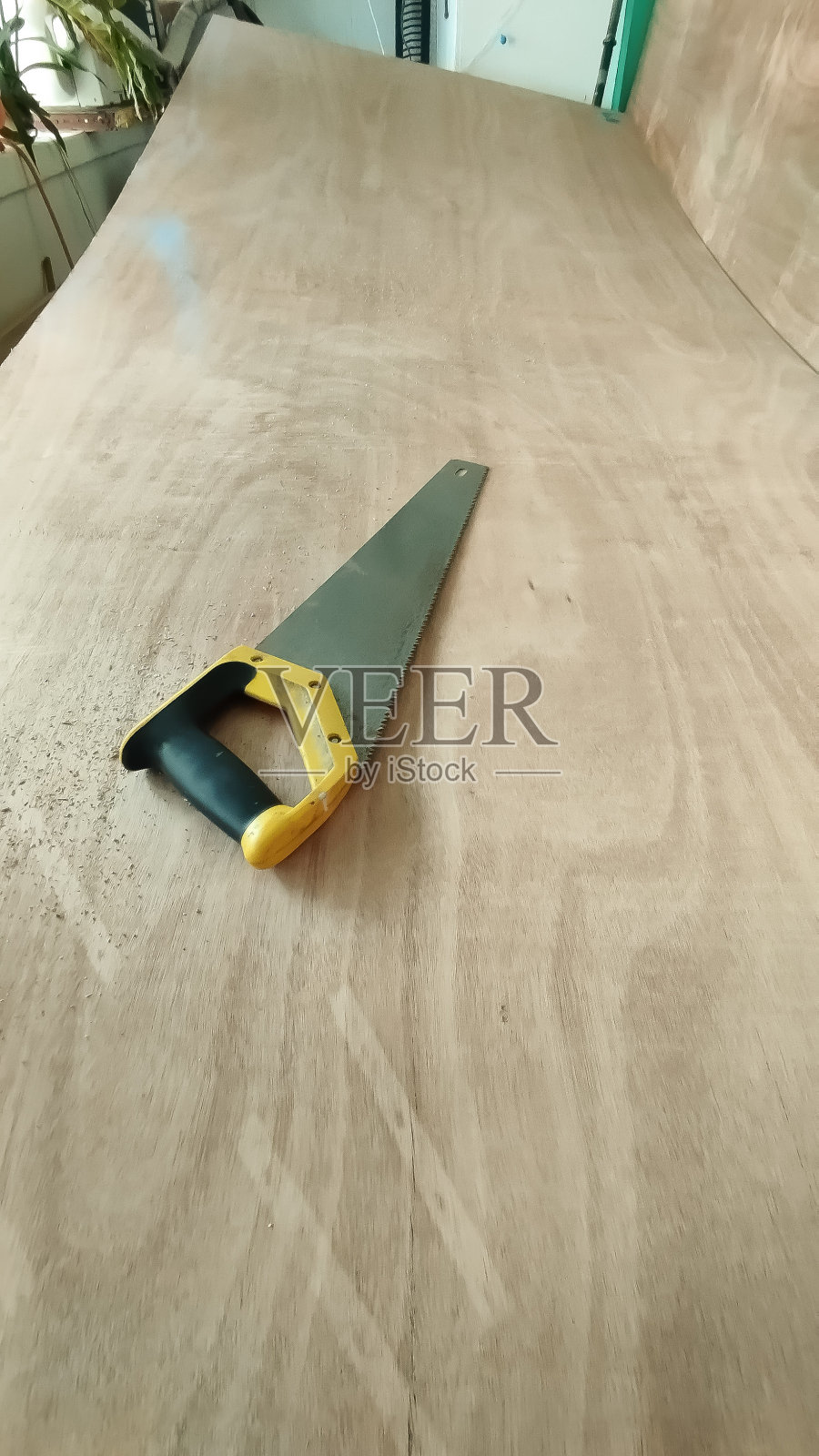 在准备切割的胶合板上安装钢锯照片摄影图片