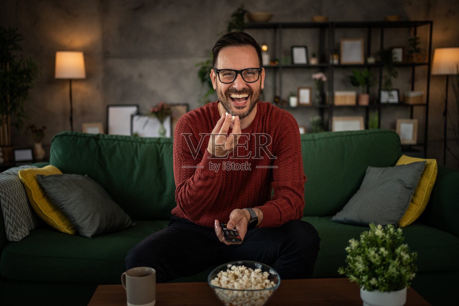 一个男人舒服地坐在沙发上看电视照片摄影图片