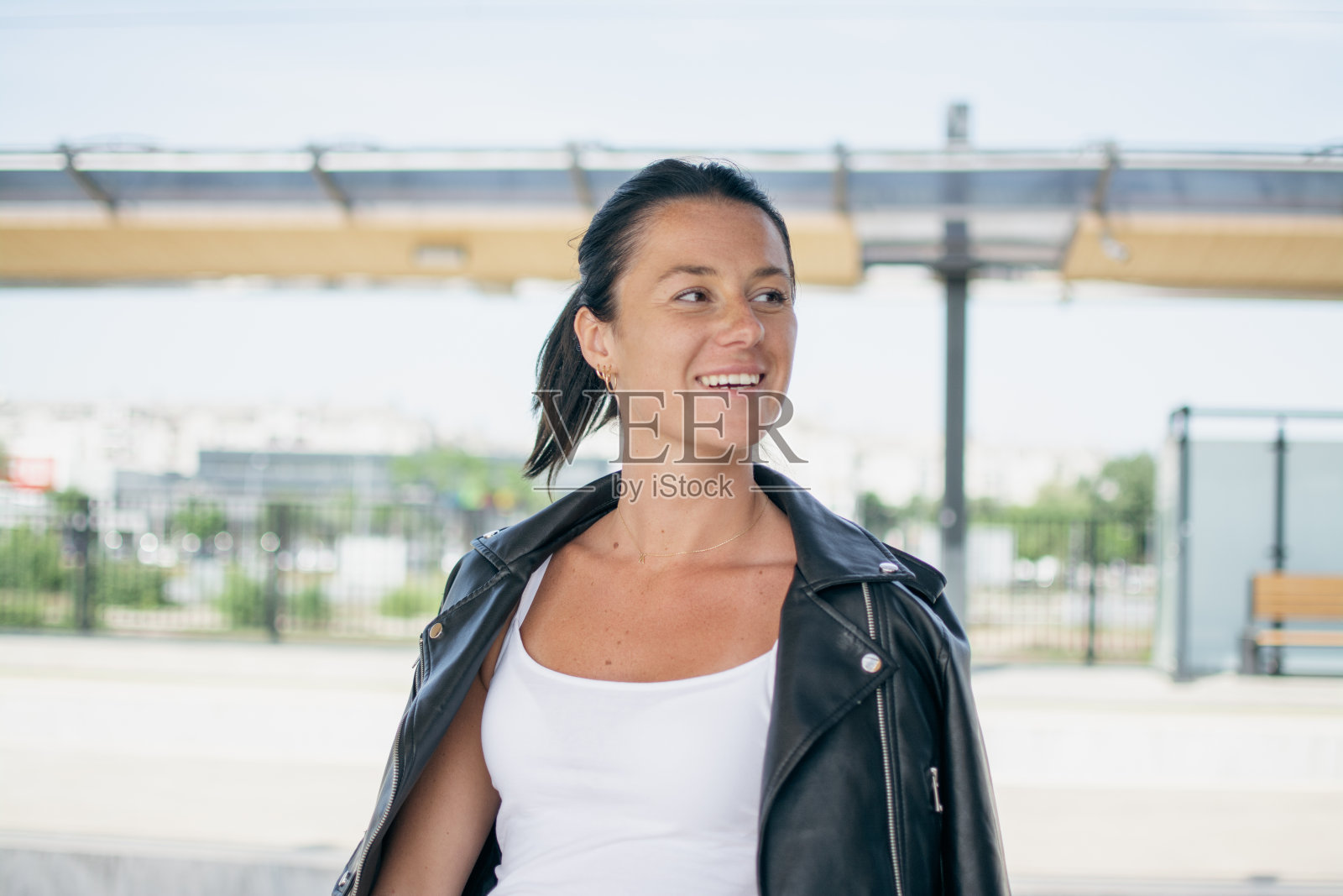 一个欢快的棕色皮肤的女孩等待火车旅行的肖像照片摄影图片