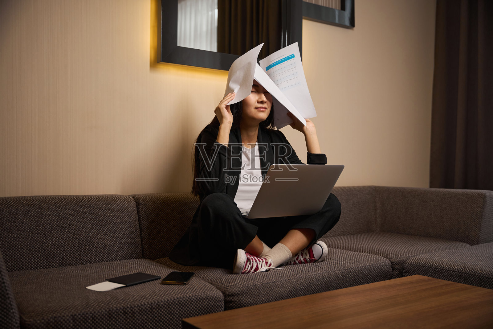 年轻的女人在用纸和笔记本电脑工作照片摄影图片