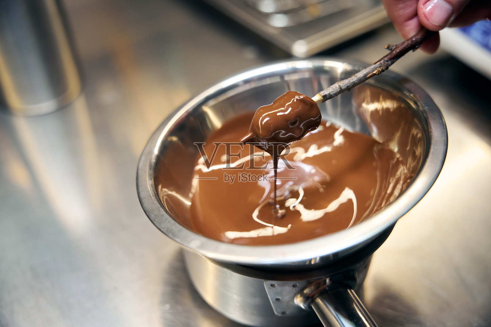 部分男厨师在做饭时把碗里的巧克力涂在树枝上照片摄影图片
