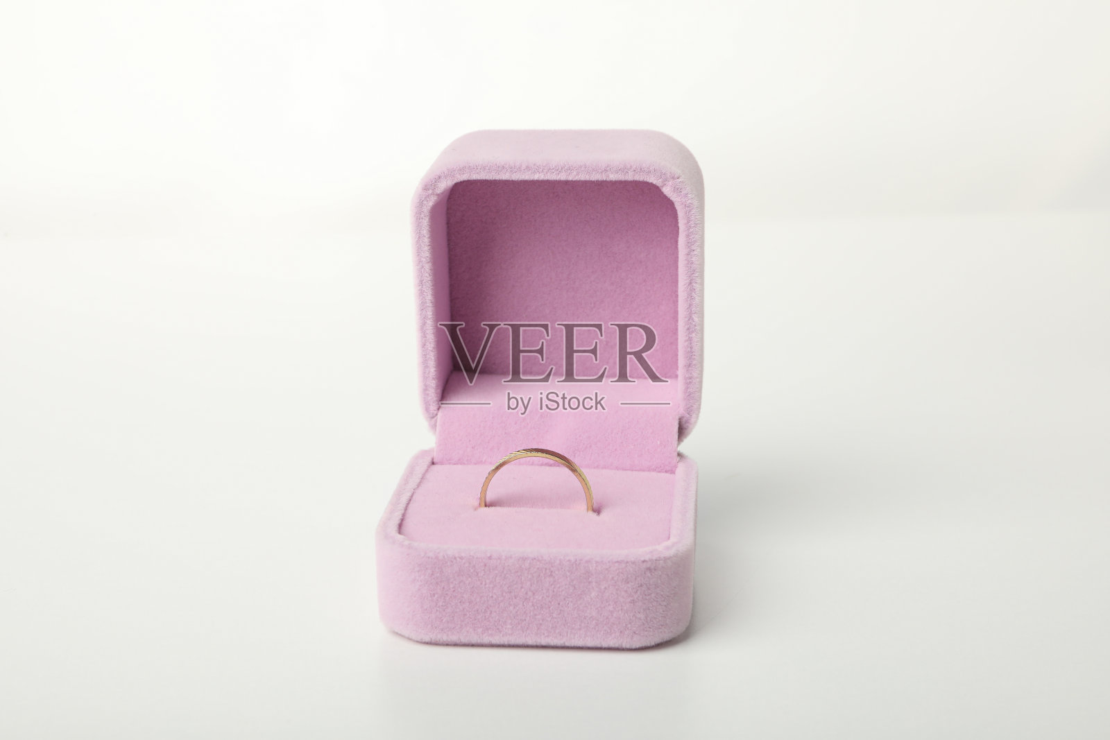 白色背景上粉色盒子里的结婚戒指，特写照片摄影图片