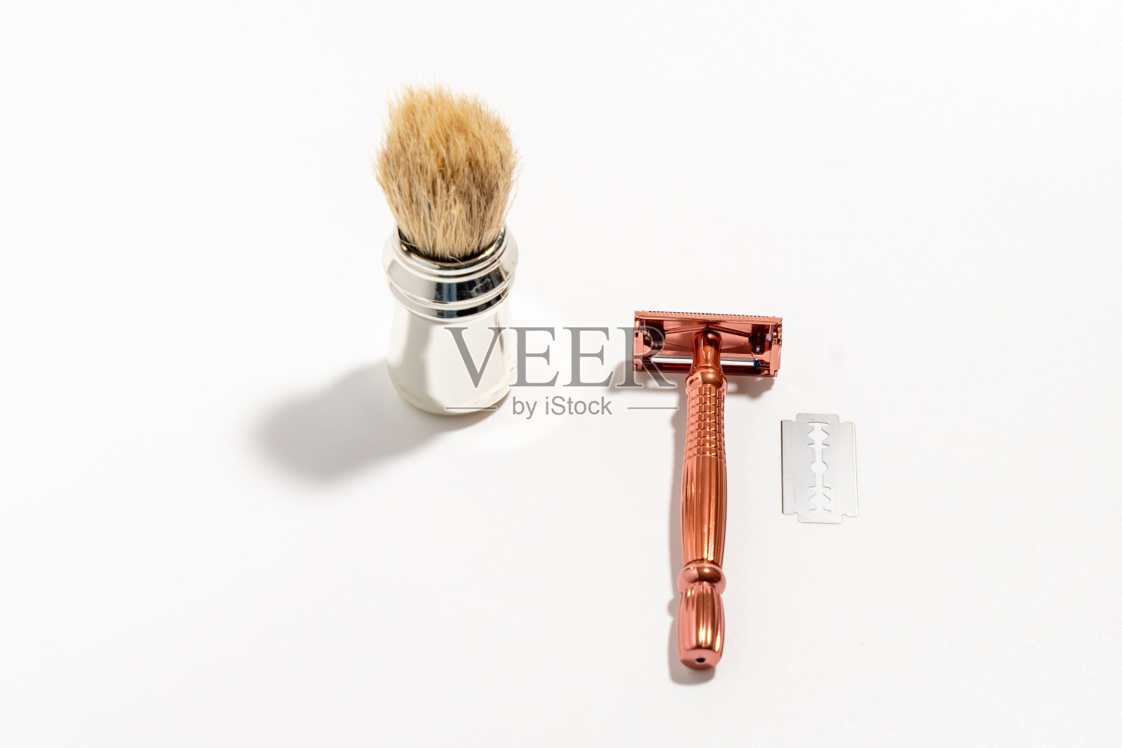 白色背景上的金属剃刀和笔刷。照片摄影图片