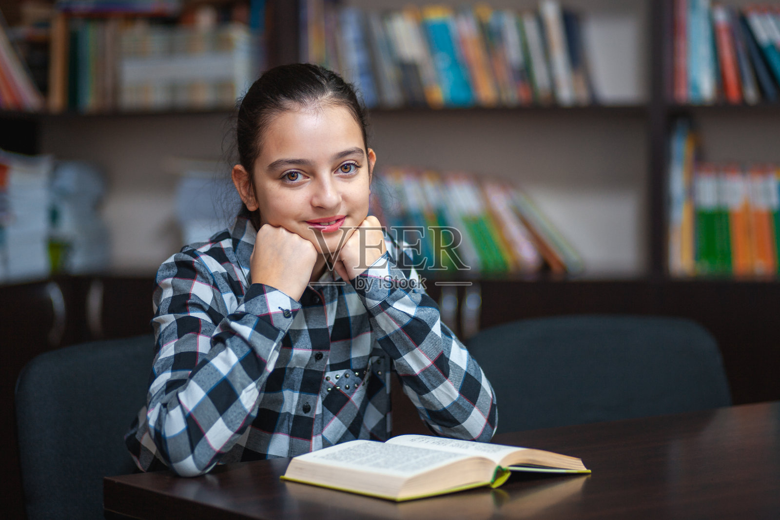 漂亮的女学生坐在图书馆看书照片摄影图片