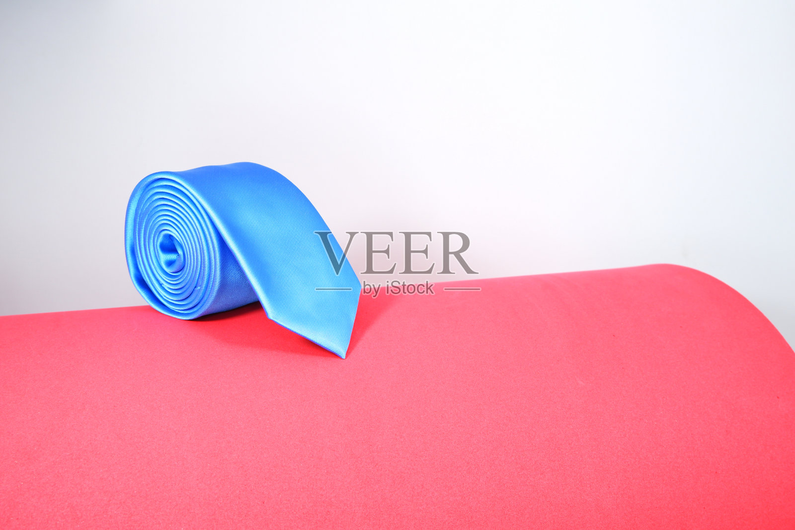 红色地毯上的蓝色涤纶领带照片摄影图片