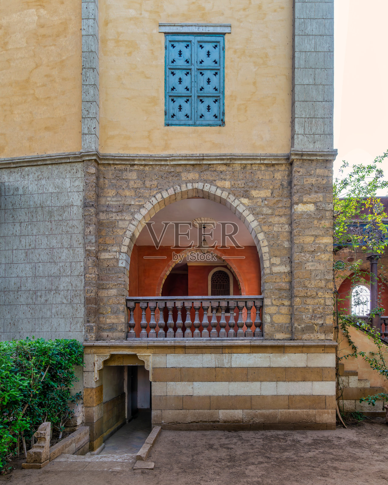 具有拱形木制阳台和精致窗栅的乡村风格建筑的宁静景色照片摄影图片