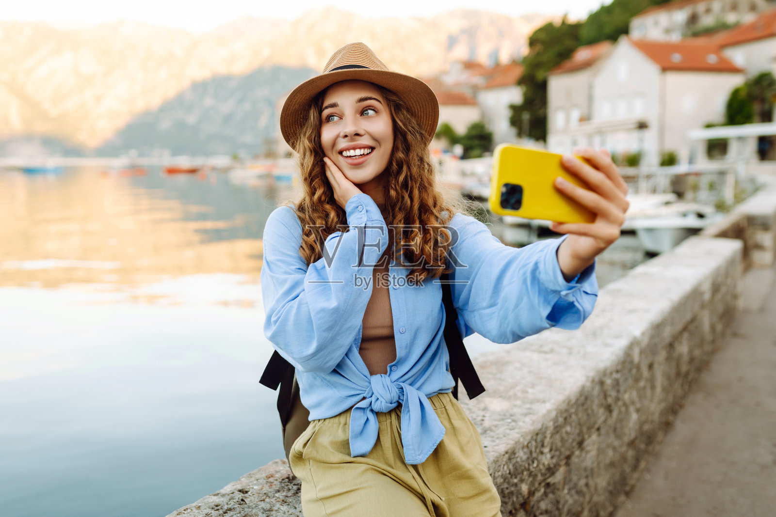 年轻的女游客正在探索新的城市，用智能手机拍照。照片摄影图片