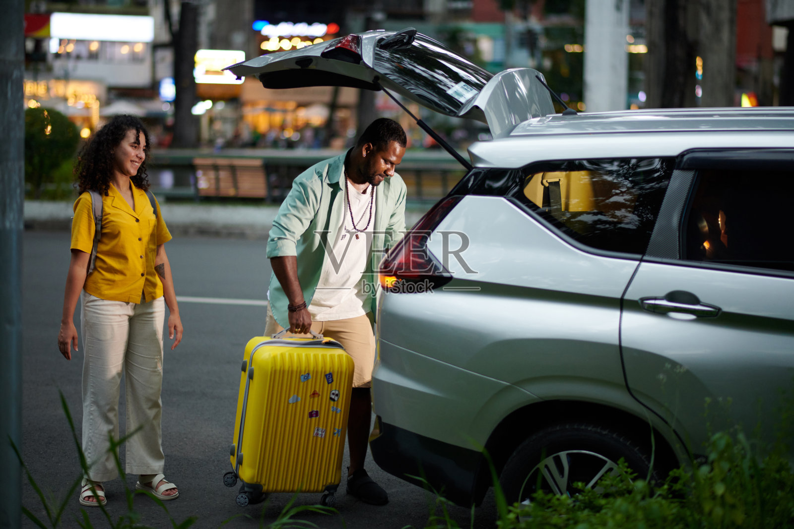 把打包好的行李箱放进汽车后备箱照片摄影图片