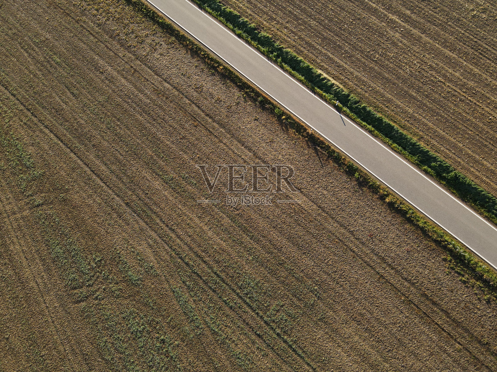 从上面看到的犁过的田地和乡间的道路照片摄影图片