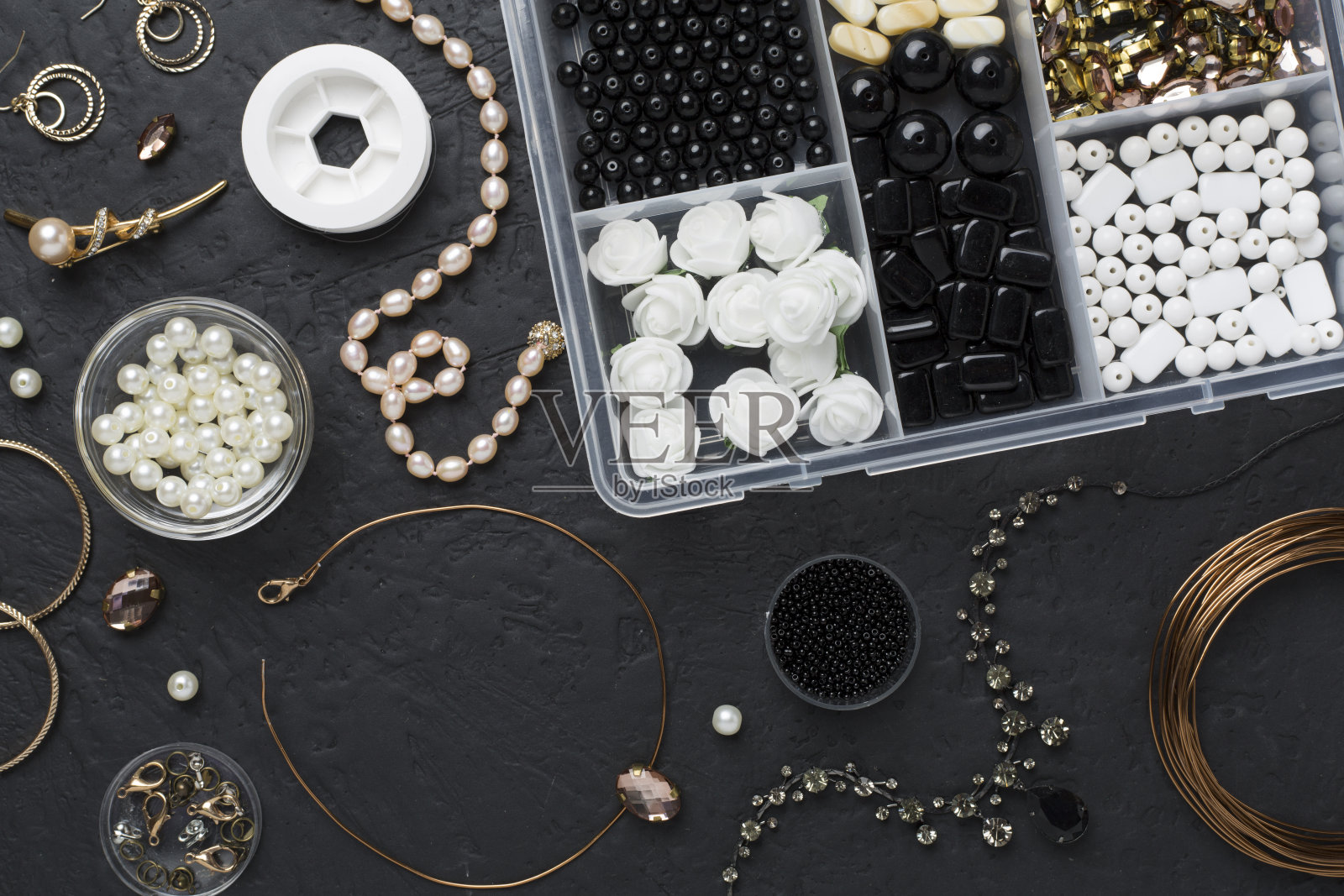 在混凝土背景上制作手工珠宝的工具和珠子，俯视图照片摄影图片