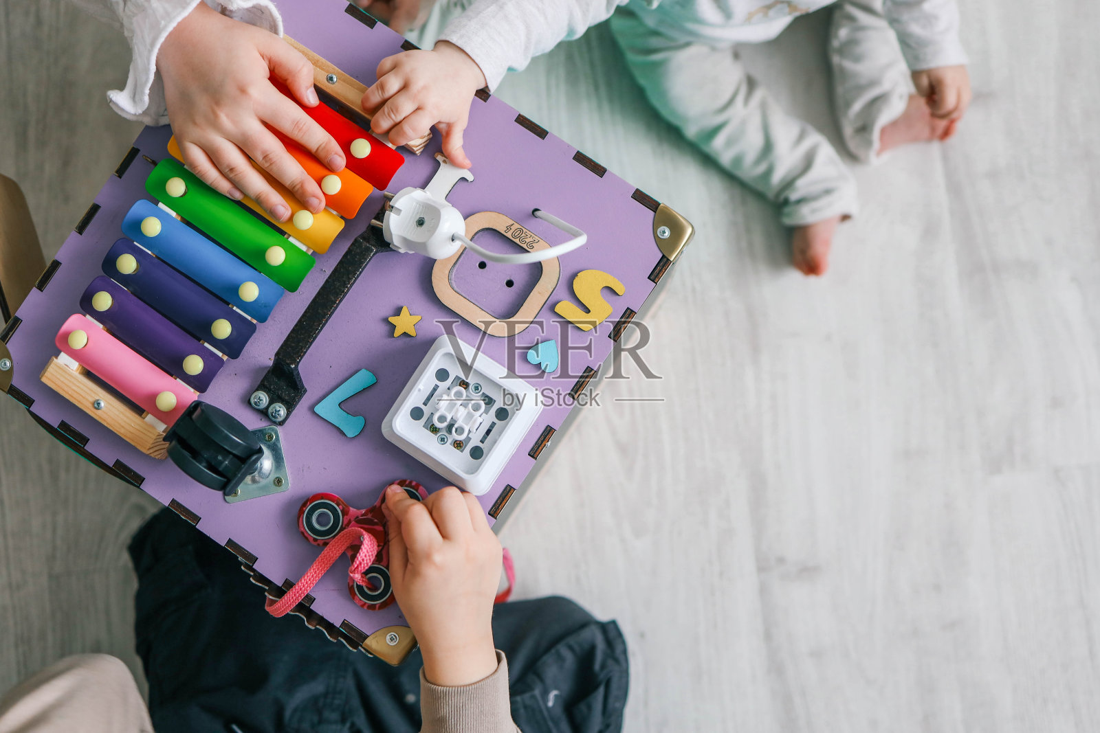 孩子们在幼儿园里一起玩耍，手工制作的忙碌板，俯视图照片摄影图片