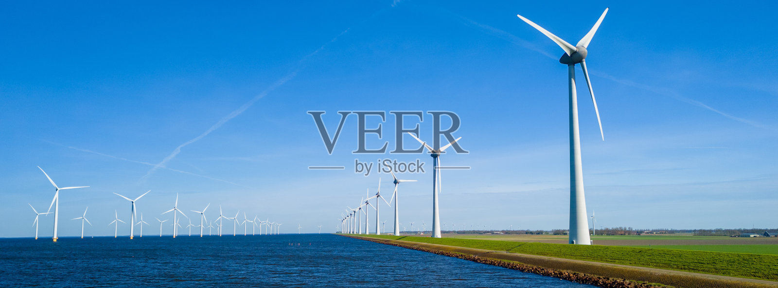 荷兰弗莱福兰的宁静景象，在春天有一排风景如画的风力涡轮机照片摄影图片