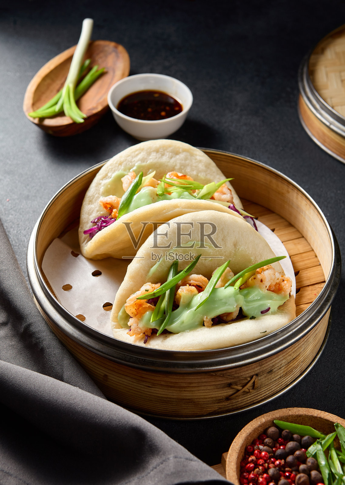 在深色的餐桌上，包着虾、紫甘蓝和芥末照片摄影图片