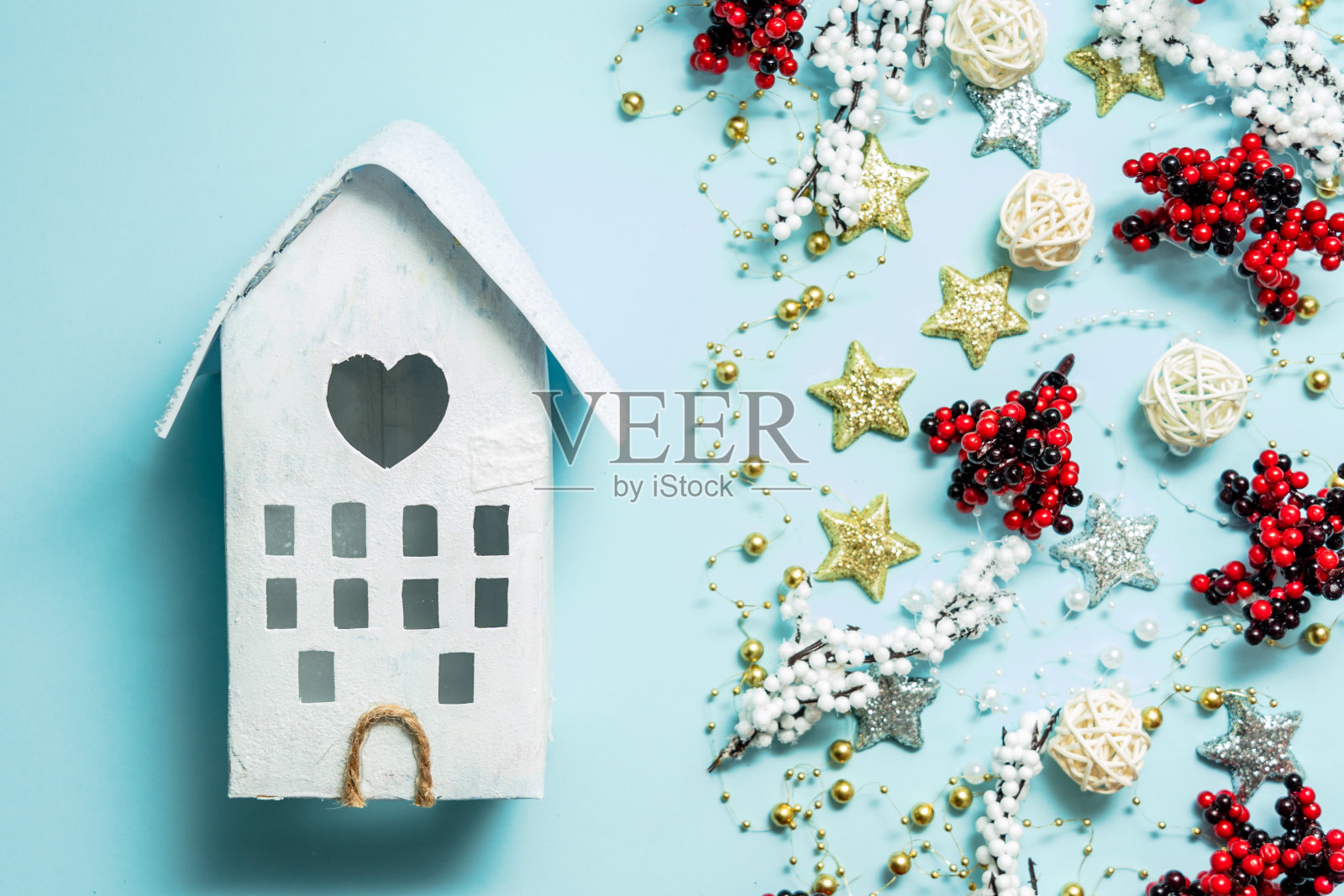 圣诞或冬季构图在浅蓝色的背景与玩具屋。冬季、圣诞节或新年的概念。平躺照片摄影图片