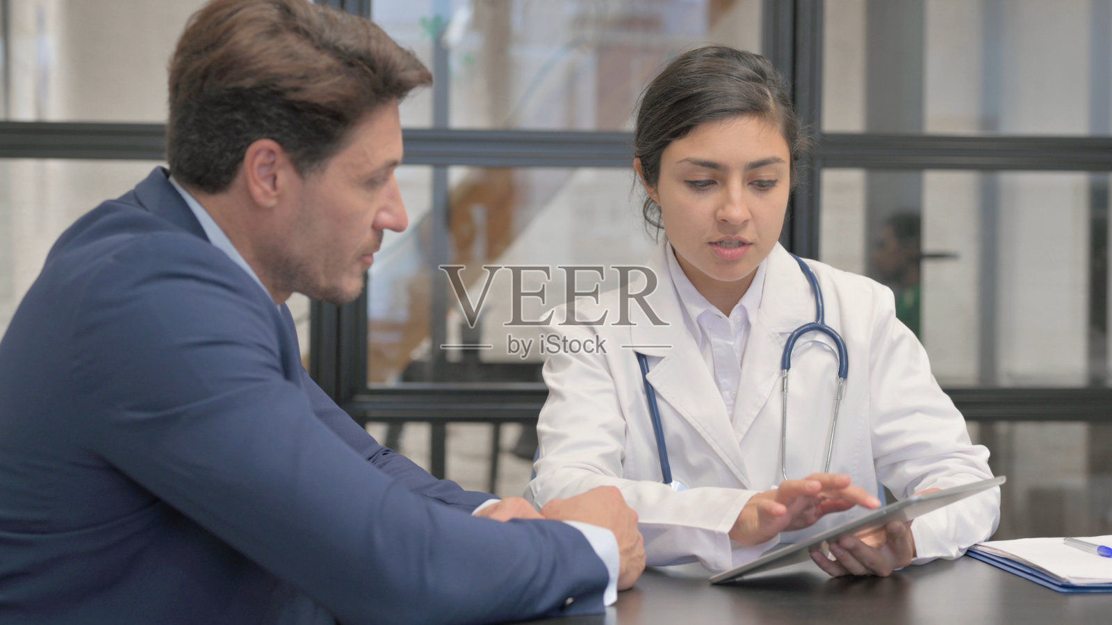 印度女医生在诊所与病人交谈照片摄影图片