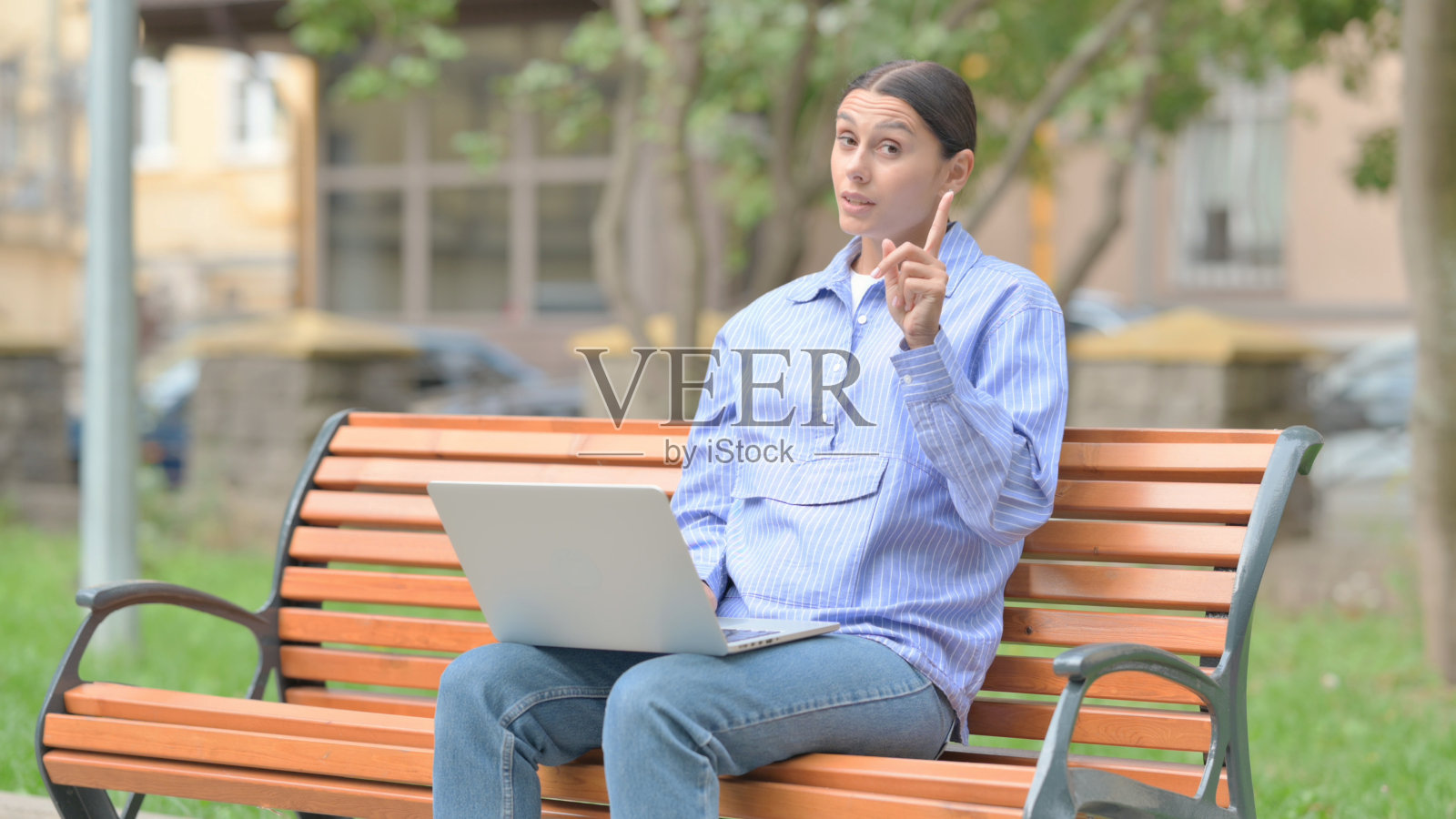 一名西班牙裔女子坐在户外，否认自己在看镜头照片摄影图片